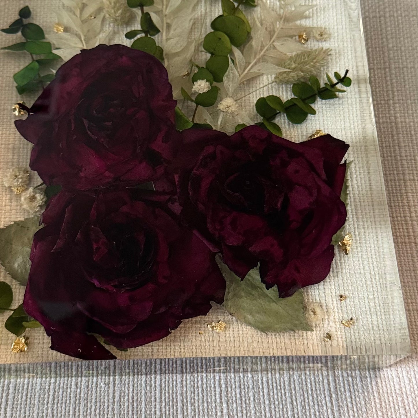 Red roses with greenery in a resin block